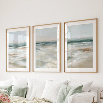 Soft blue seascape 3-piece art print set in natural oak frames with mats spans behind the sofa, layering in breezy coastal texture.