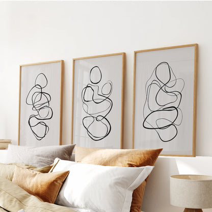 Three wooden-framed abstracts shape a quiet wall art set that settles neatly above the bedroom headboard.
