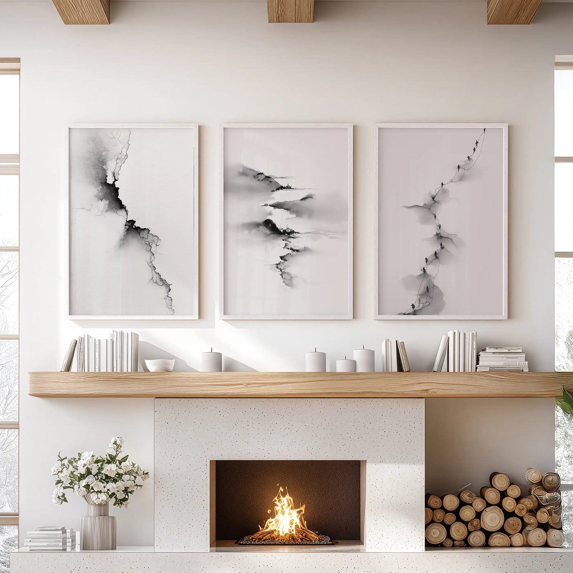 Three white-framed landscape prints center above the family room mantel, bringing airy, contemporary balance to the space.