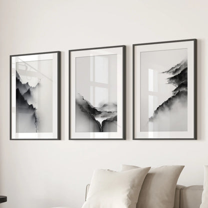 Black and white abstract mountains, a set of three wall art prints in black frames with mats, anchor the sitting room wall behind the sofa.