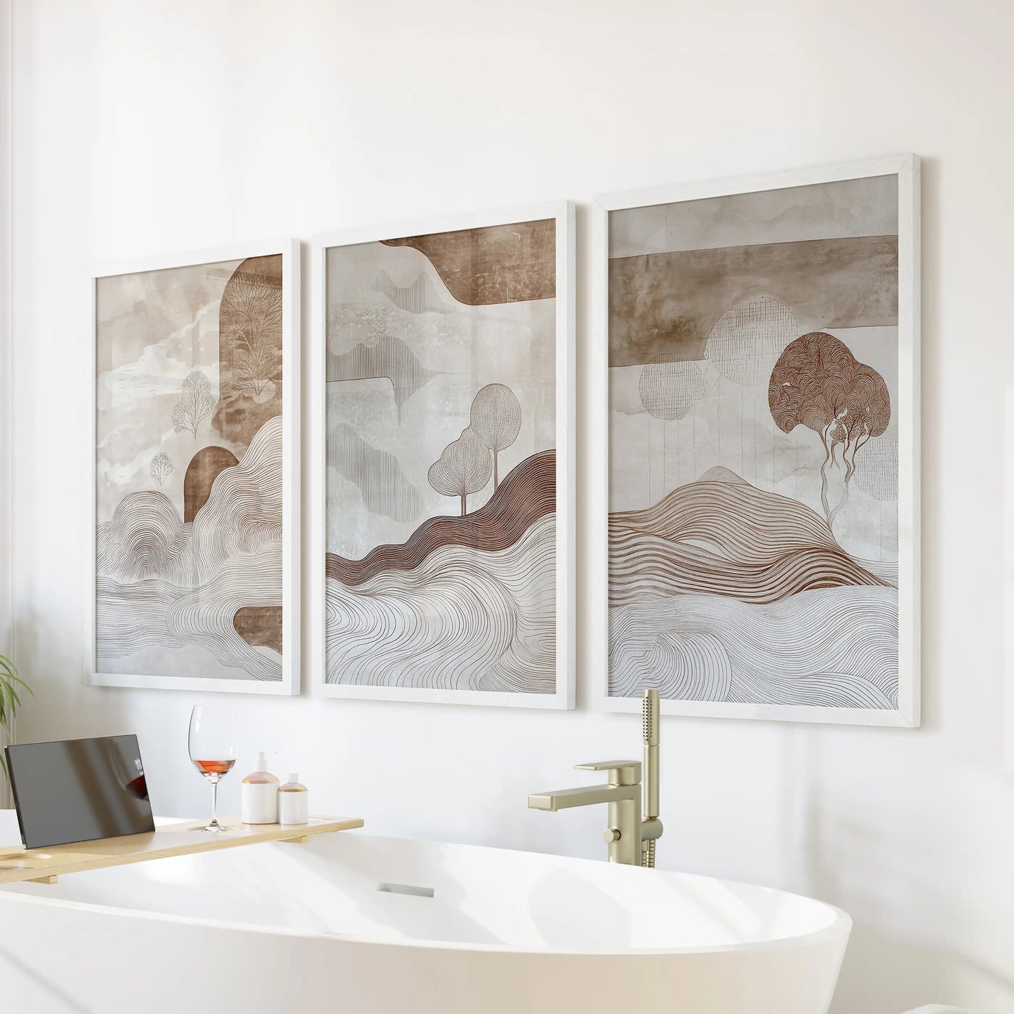 A three-piece set of earth-toned abstract artwork in white frames adds serene wall art above the bathtub for a spa-inspired bathroom.