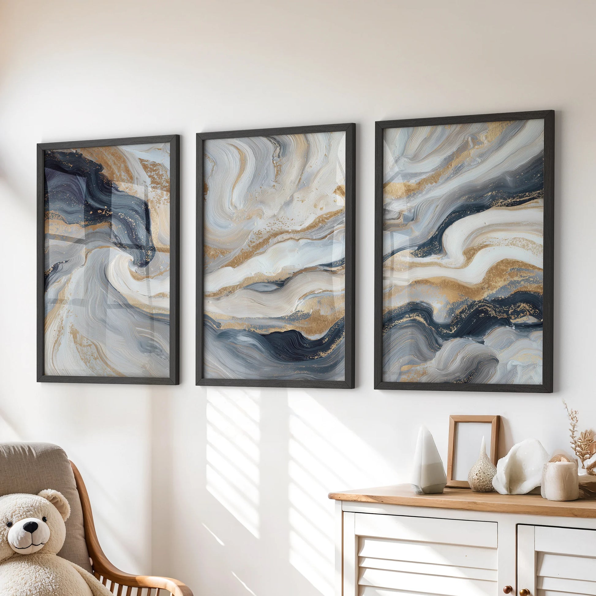 Dark blue texture and brushwork in a trio of wall art prints introduce calm color, black framed above the children’s room chest of drawers.