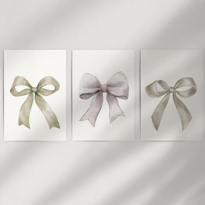 Bow motif wall art, a three-piece print set, dresses a bare wall with unframed sheets that showcase delicate neutral ribbons and airy negative space.