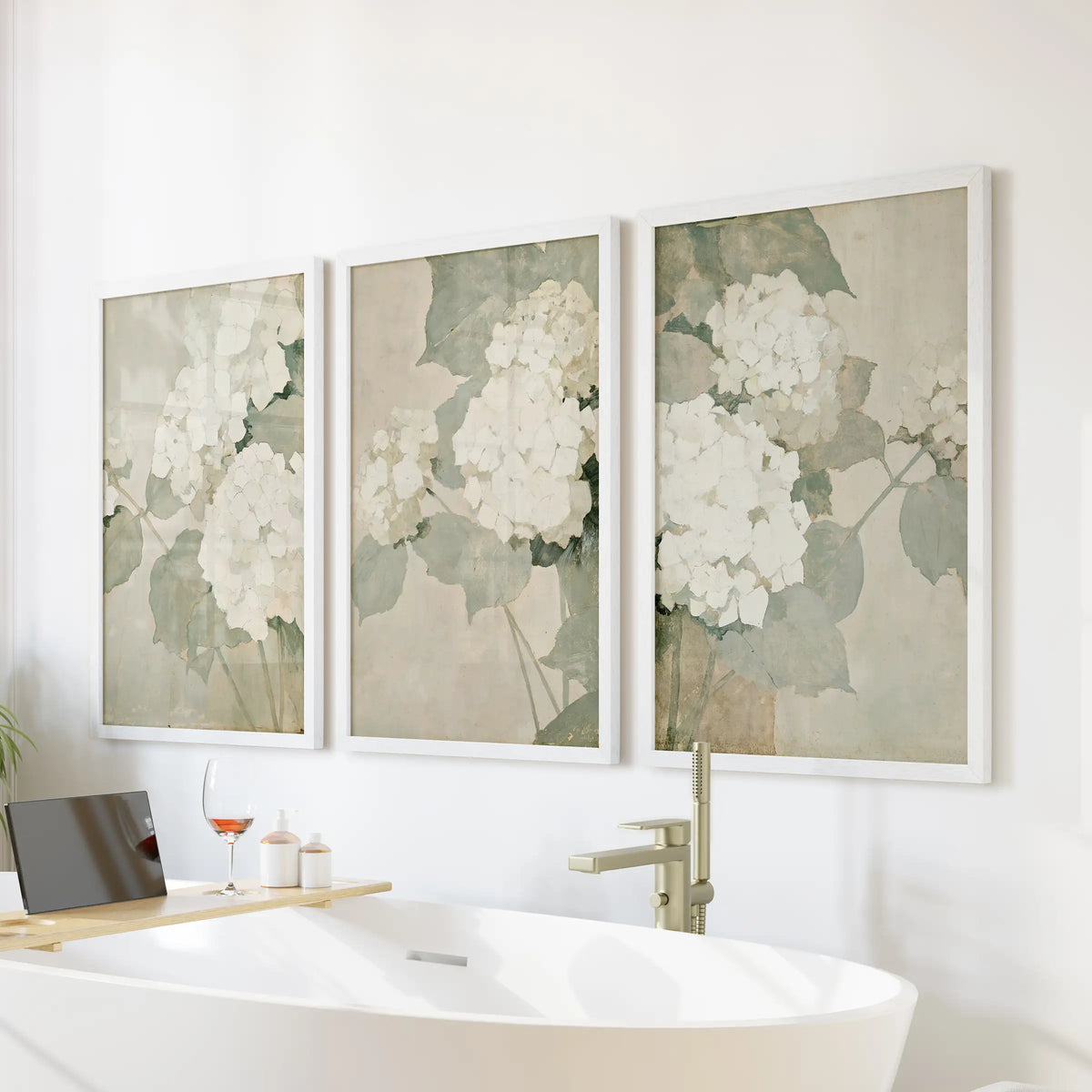 Hydrangea illustrations form a three-piece wall art set in white frames, arranged over a bathtub in the bathroom.