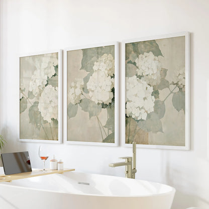 Hydrangea illustrations form a three-piece wall art set in white frames, arranged over a bathtub in the bathroom.
