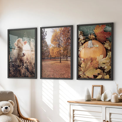 Three black-framed autumn foliage artworks hang above a kids’ room chest of drawers, lending a soft, cozy feel.