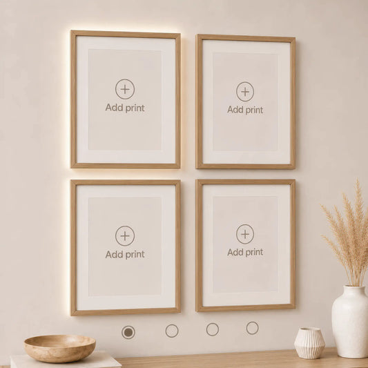 Interactive wall art builder preview showing four empty natural wood frames arranged in a 2×2 gallery layout. Customize your own wall art set by adding prints to each frame.