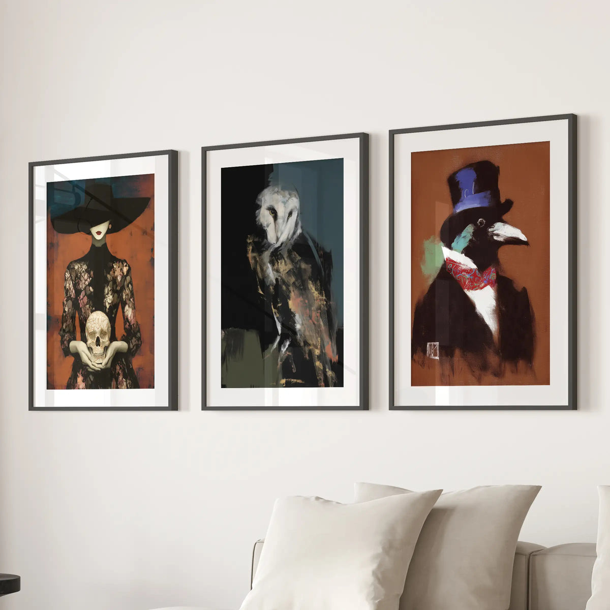 Dark academia set of three wall prints in black frames with wide mats, displayed behind a living room couch.