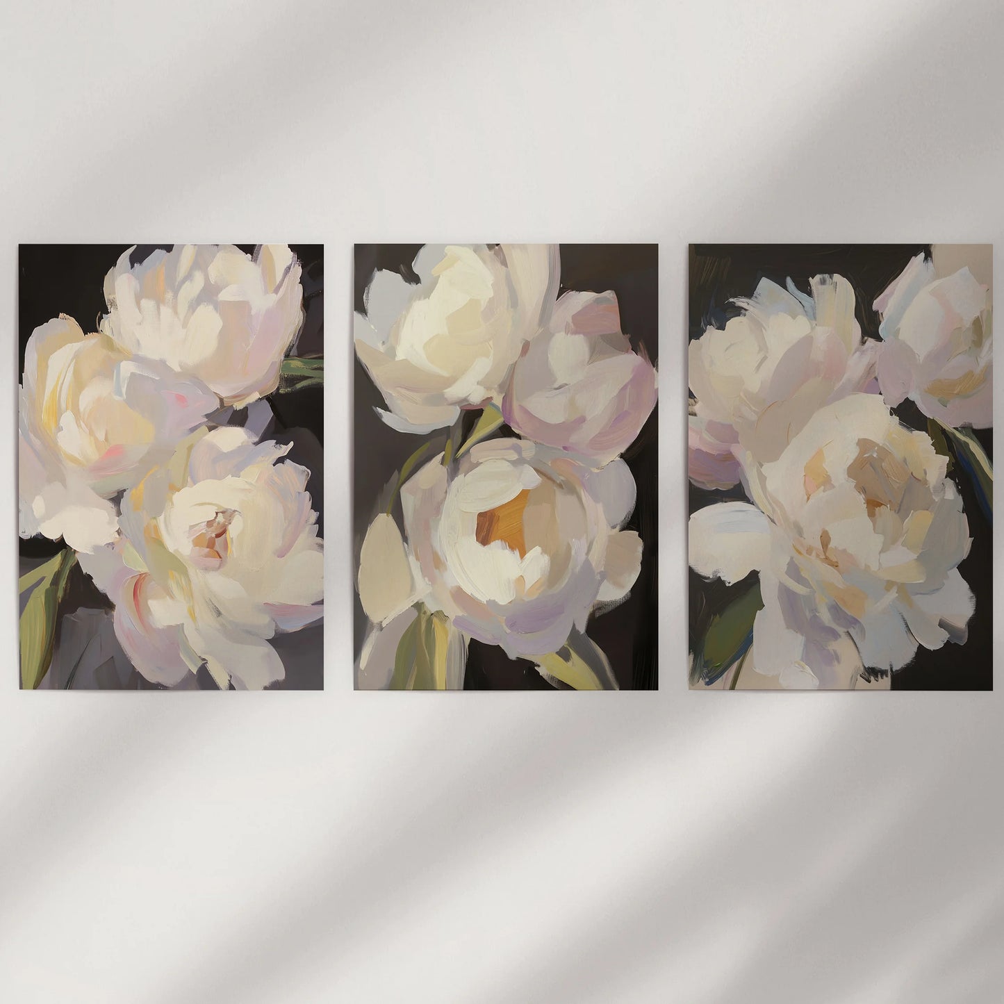 Vintage floral still lifes, a 3-print gallery wall, sit unframed on a neutral wall, letting textured brushwork and deep tones carry the room.