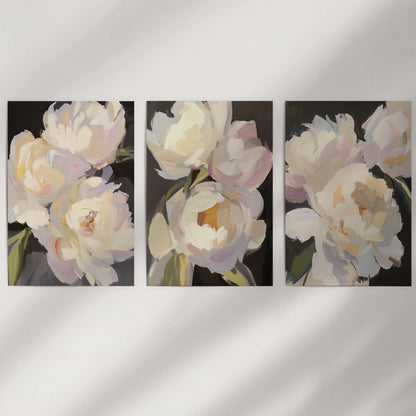 Vintage floral still lifes, a 3-print gallery wall, sit unframed on a neutral wall, letting textured brushwork and deep tones carry the room.