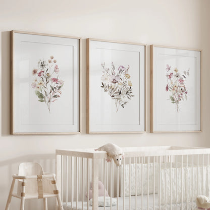 Three light-wood framed plant illustrations, softly matted, rest over the crib to sweeten the nursery’s wall with calm green detail.