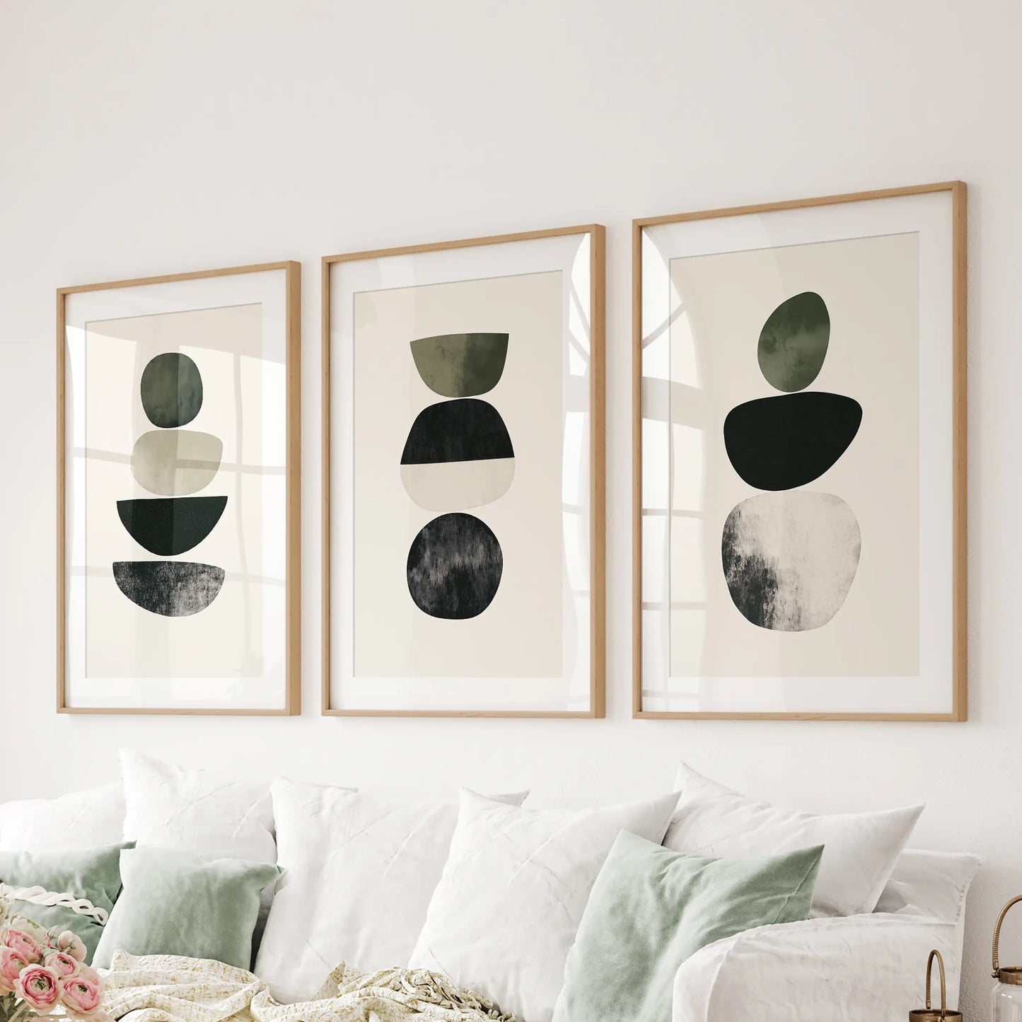 Organic shapes in a neutral palette 3-piece artwork set brings calm wall art to the living room, in oak frames with mats hanging over the sofa.