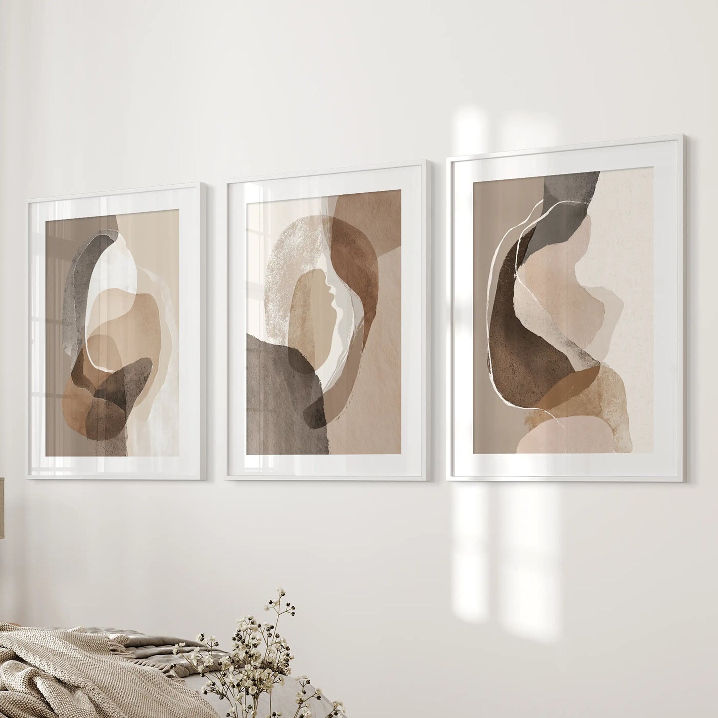 Boho abstract shapes gallery wall set of 3 art prints, matted in white frames, lines the bedroom wall beside the bed for a serene, modern accent.