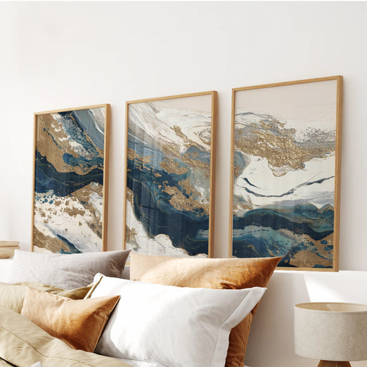 Three-piece artwork with subtle abstract textures settles above the bed, enclosed in light wood frames for a gentle mix of contrast and calm.