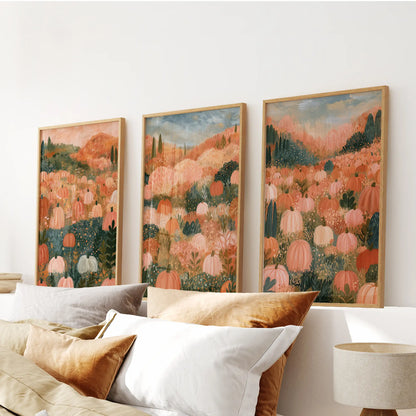 A set of three wall hangings features folk art pumpkins in solid oak frames, centered over the bedroom bed with nostalgic autumn tones.