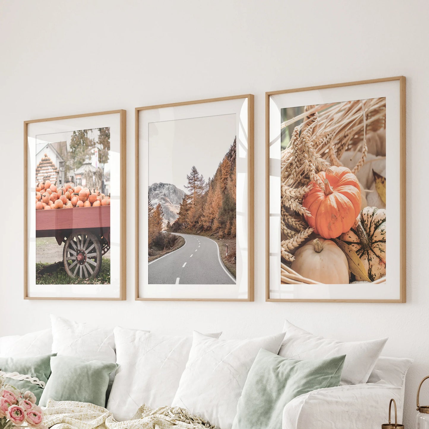 Fall landscape photography three-piece artwork set, oak frames with mats arranged over the sitting-room sectional, layers depth and horizon line.