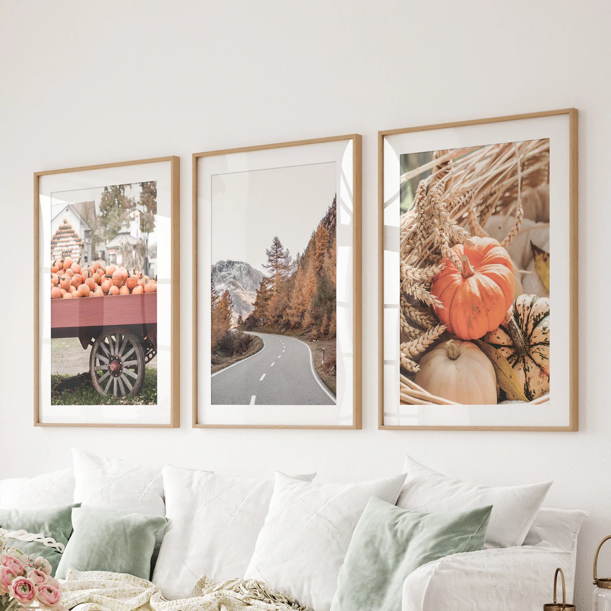 Fall landscape photography three-piece artwork set, oak frames with mats arranged over the sitting-room sectional, layers depth and horizon line.