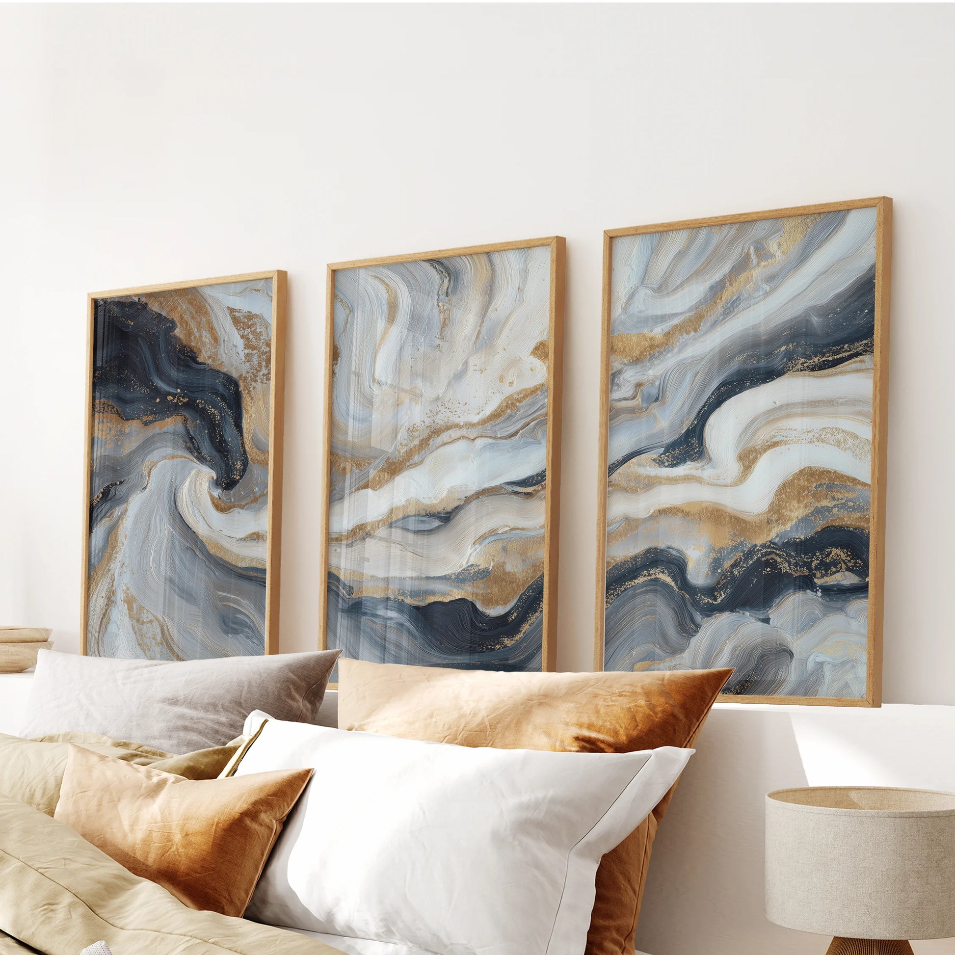 Dark blue texture and brushwork in a trio of wall art pictures settle the bedroom, shown in oak frames hung above the bed.