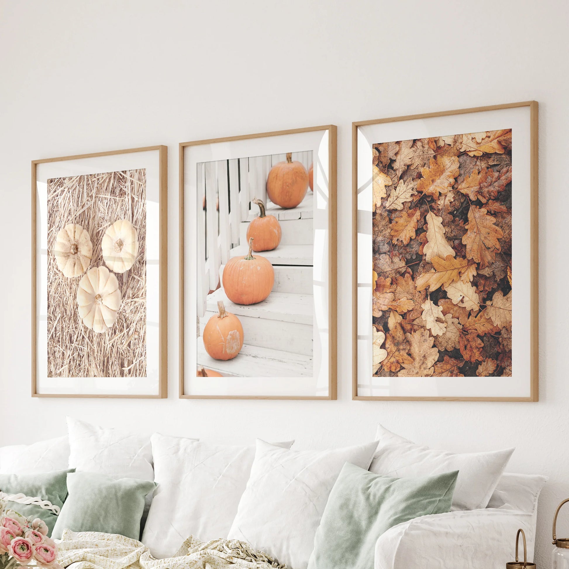 Three light-oak matted prints of fall harvest still lifes rest behind the sitting-room couch, bringing refined pumpkin hues to the space.