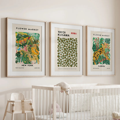 Over the bassinet, a trio of Flower Market posters in oak-matted frames layers soft color into the infant room.