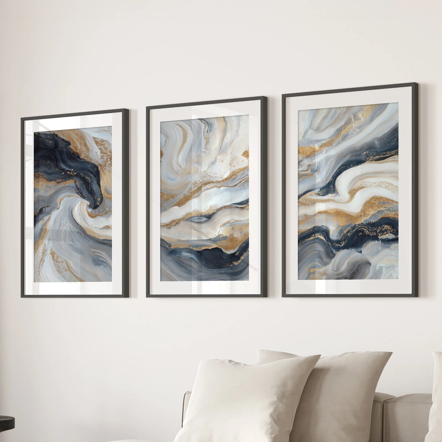 Blue and beige fluid swirls with gold accents, a 3-piece poster wall art set, hang in black frames with mats above the family room sofa.