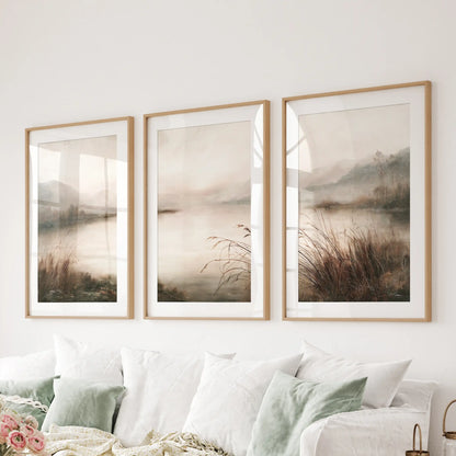 Set of three foggy woodland lake posters in matted oak frames, hanging over a sofa in the living room.