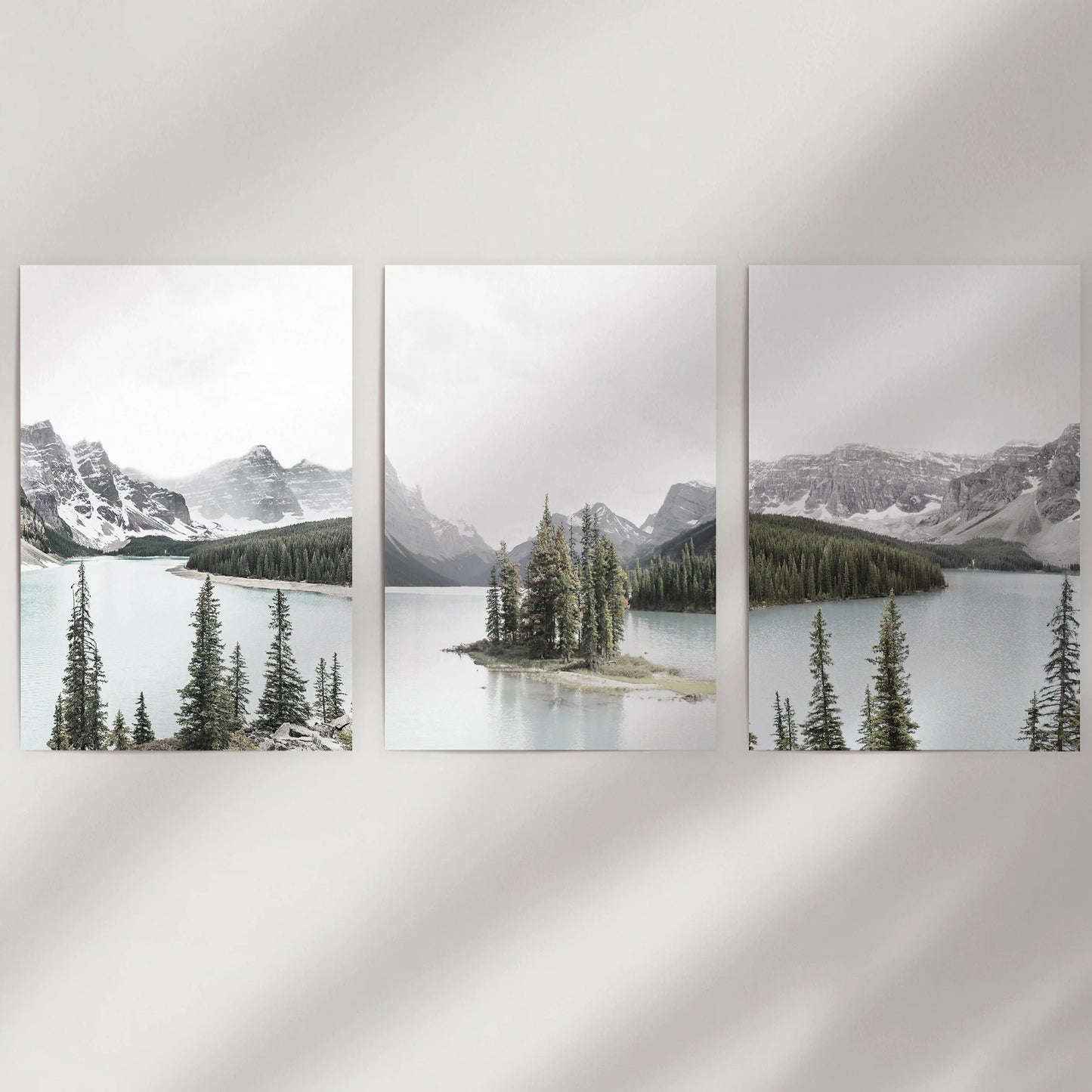 A rolled 3-piece wall art set of mountain lake and evergreen forest spreads across a white wall, offering crisp detail and open, airy space.