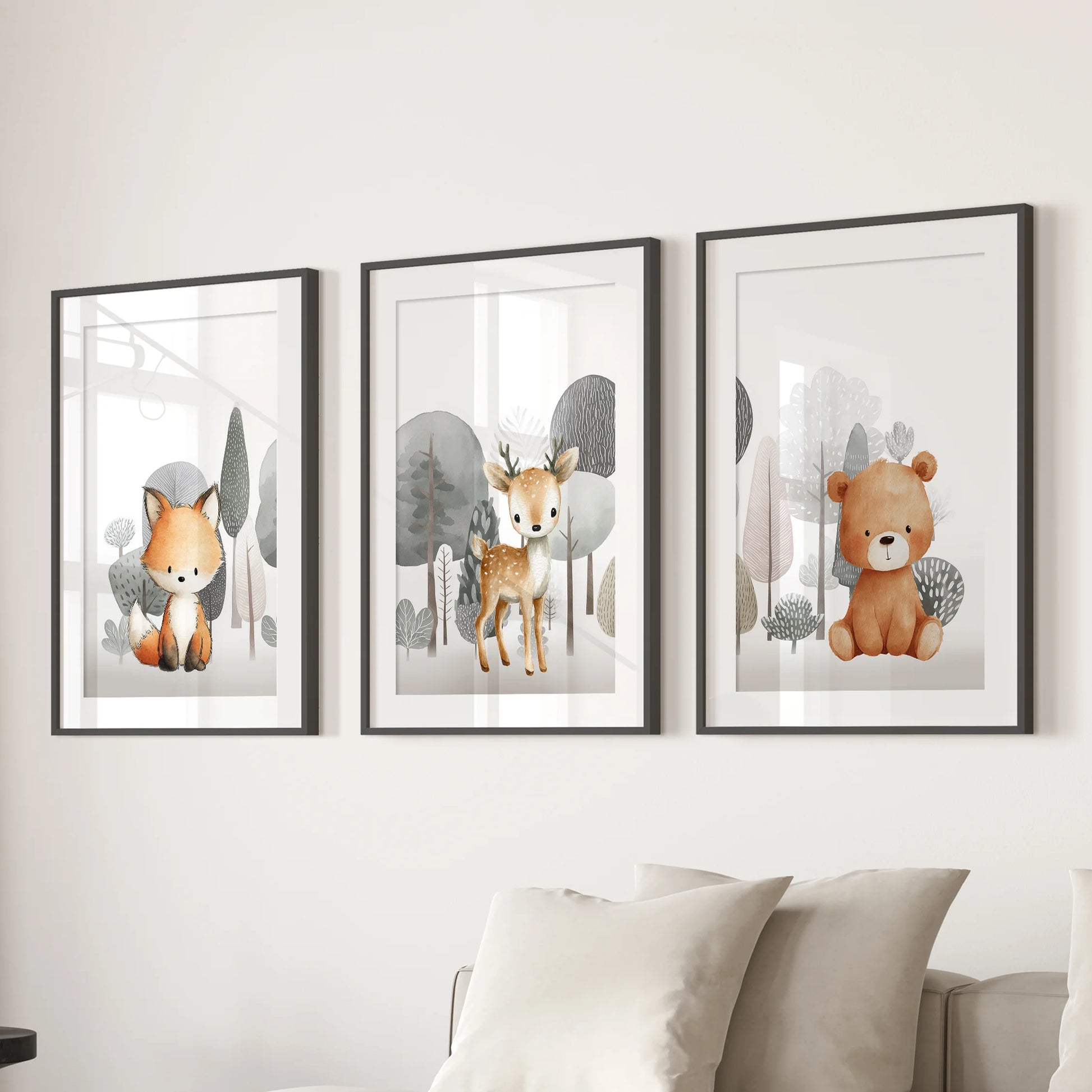 This three-print wall art set of baby forest animals, in black frames with white mats, grounds the living room above the sectional sofa.