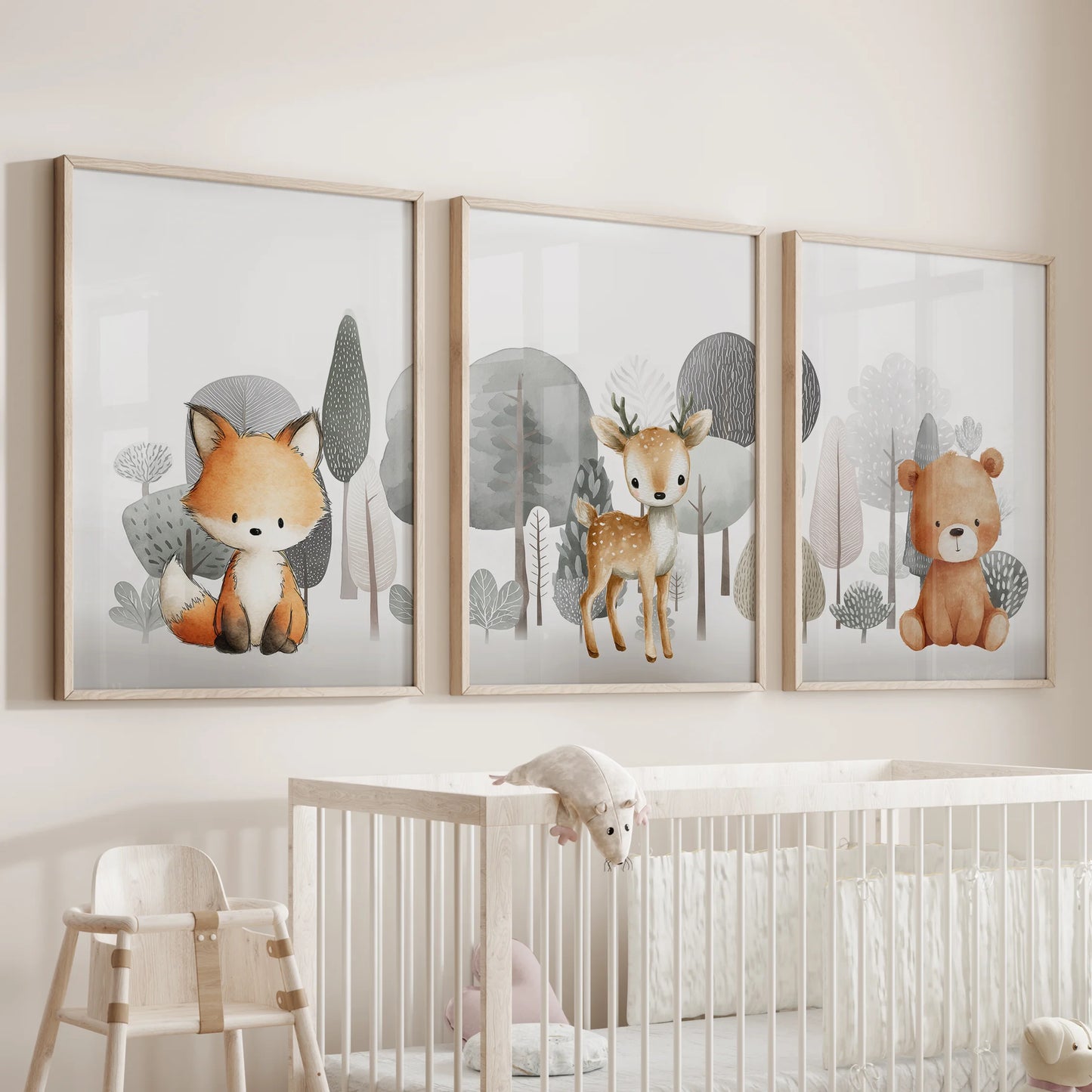 Baby forest animals in a three-piece wall hanging, set in natural wood frames, watch gently over the baby room crib.