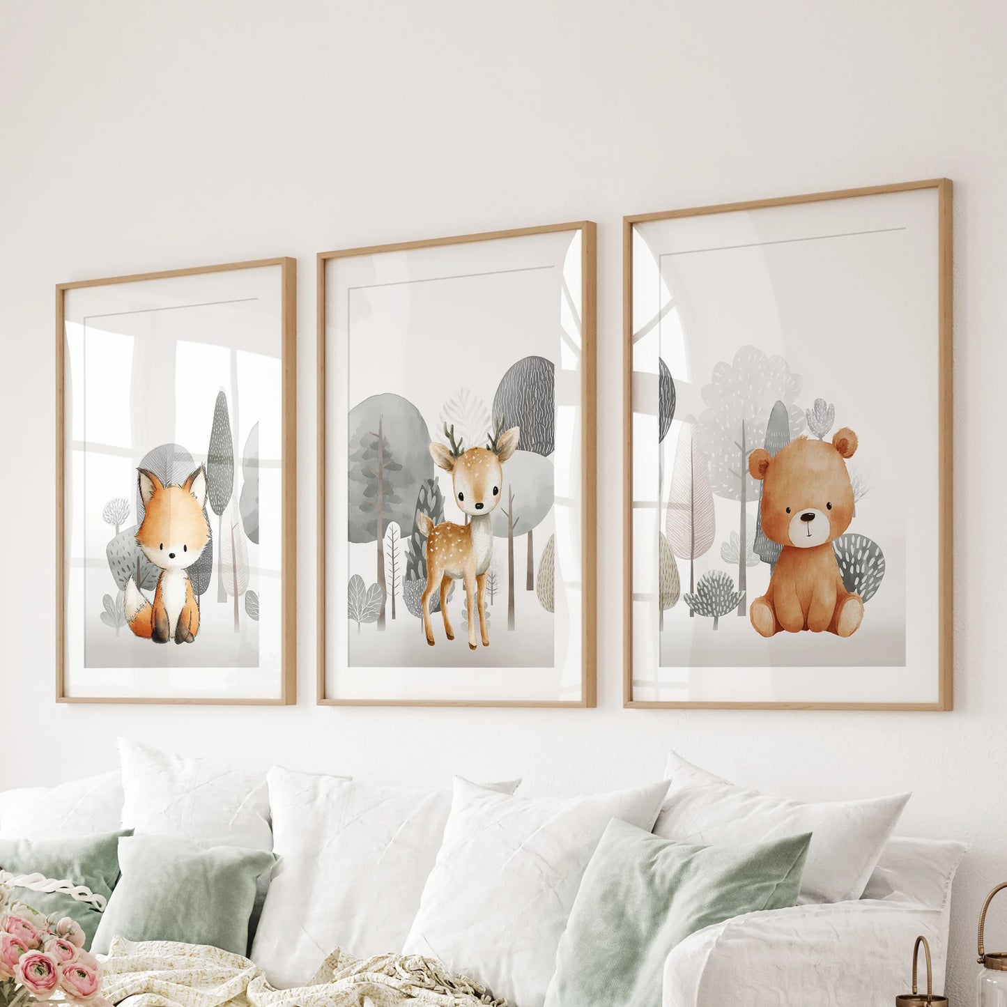 Three matted prints of a fox, fawn, and bear in natural wood frames line the living room wall above the sectional seating.