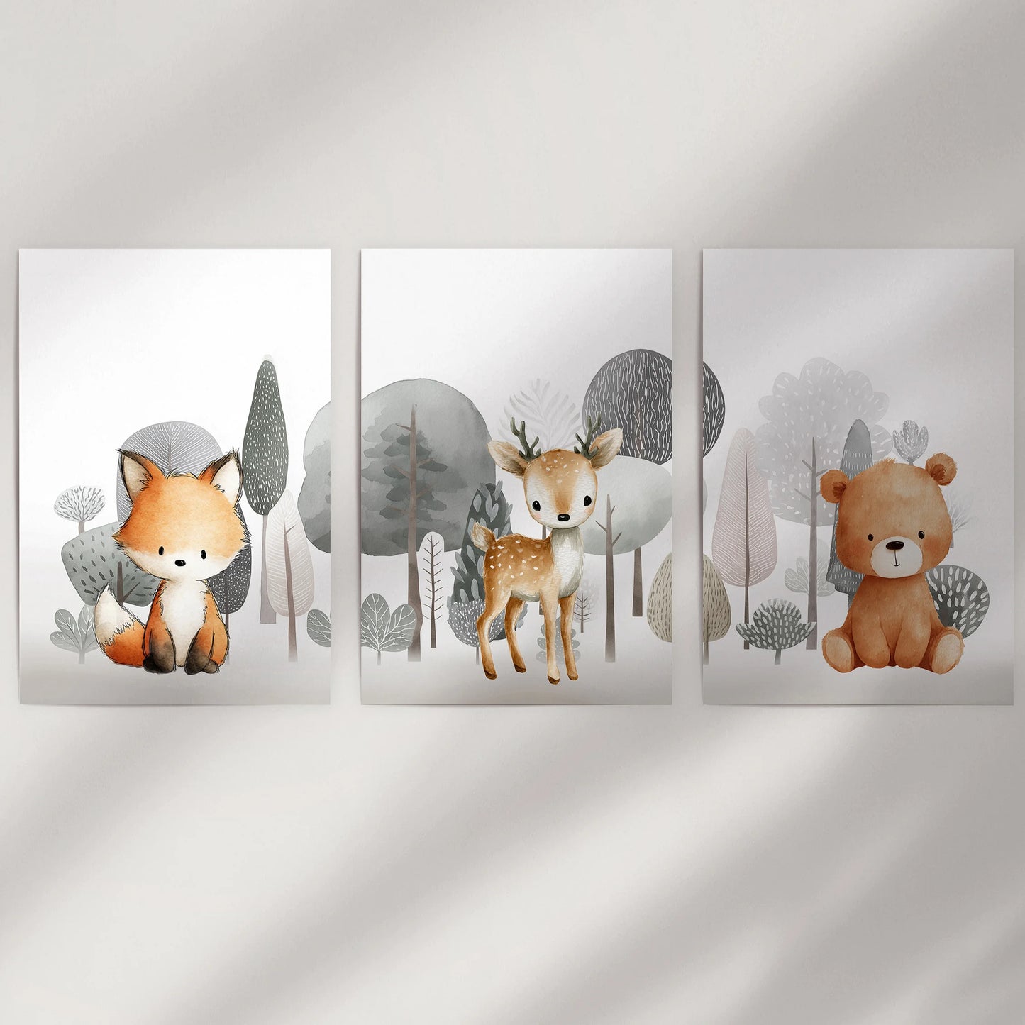 Fox, deer fawn, and bear cub in a gallery wall of three unframed art prints bring gentle woodland charm to an empty wall space.