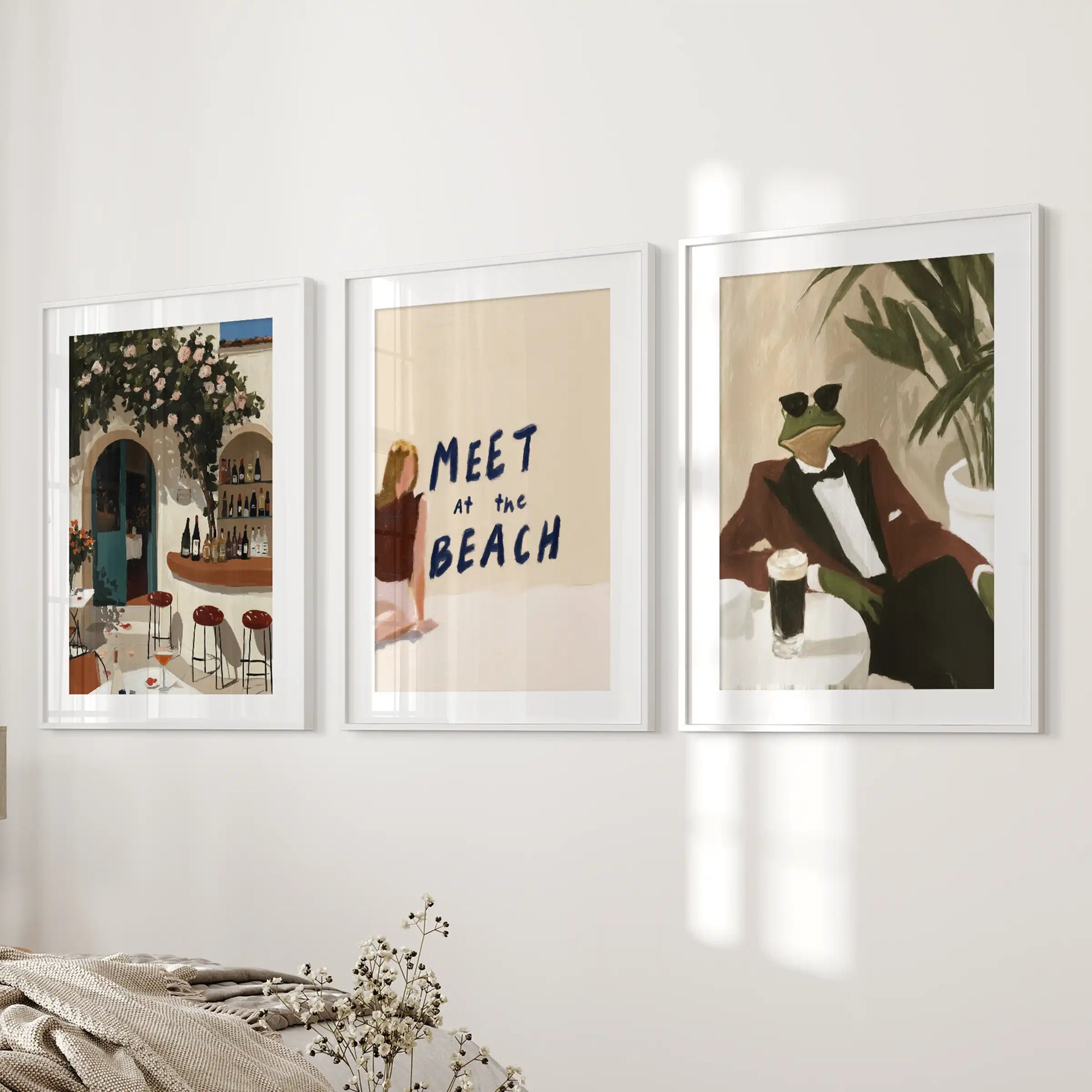 White-matted, white-framed Mediterranean beach prints in a calming trio bring soft texture and restfulness to the bedroom by the bed.