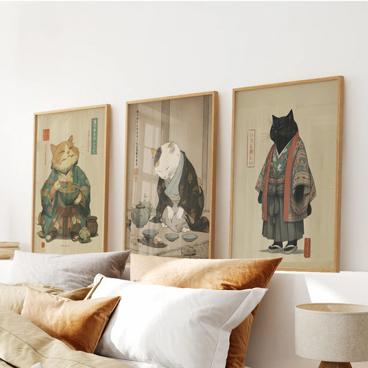 Above the bed, three natural-wood posters featuring a tea-ceremony cat rest in calm rhythm, giving the bedroom a tranquil ritual mood.