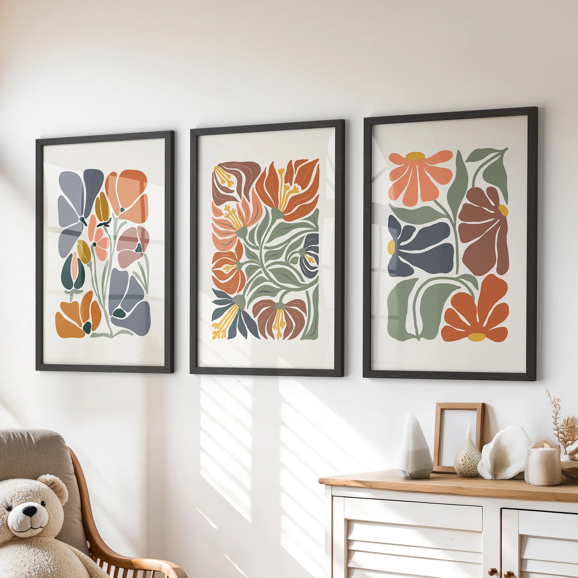 Vintage-inspired botanical prints, a framed trio in black, add playful color to the playroom wall over the chest of drawers.