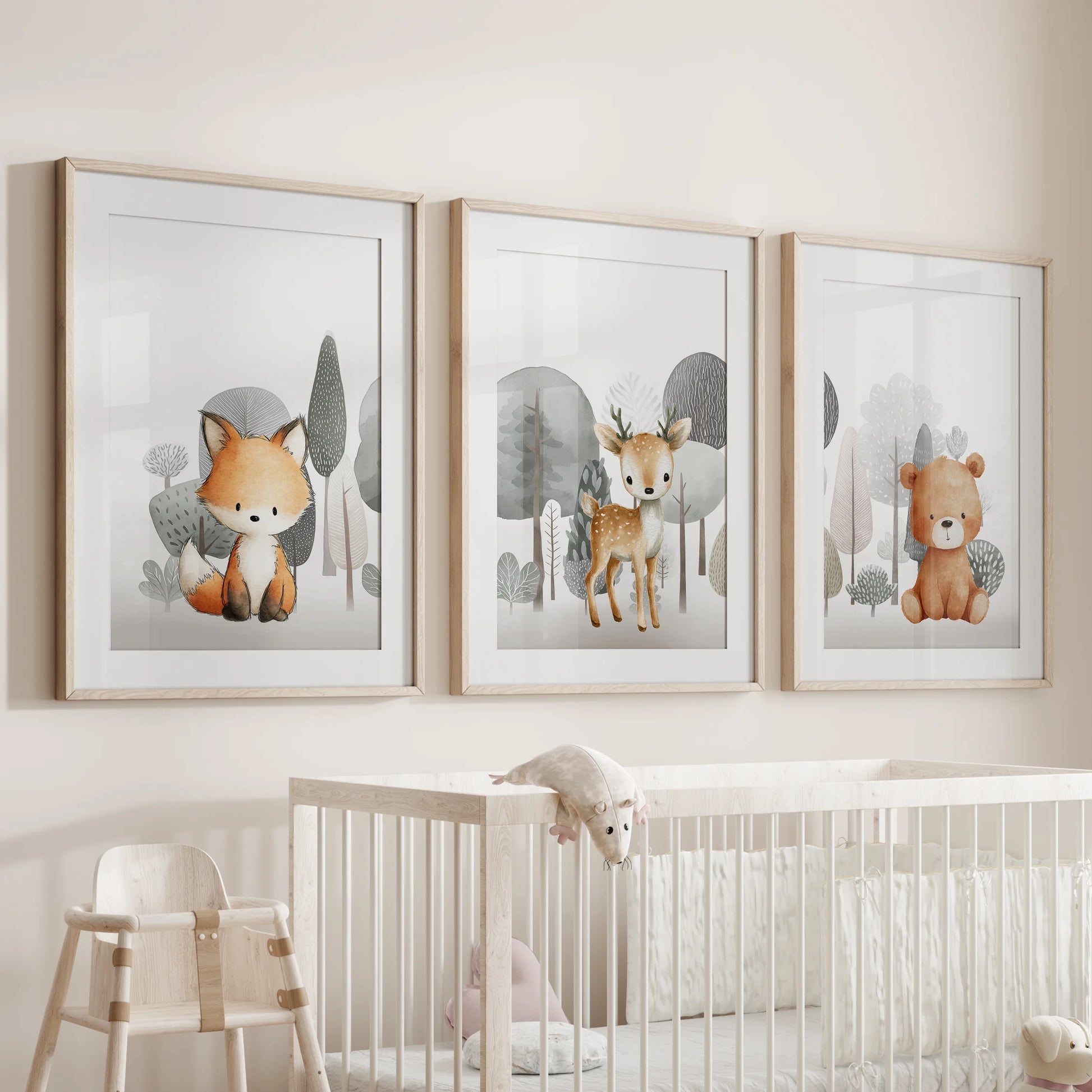 Cuddly woodland creatures in a 3-pc wall art set, with natural wood mats and frames, sit softly over the cot in the infant room.