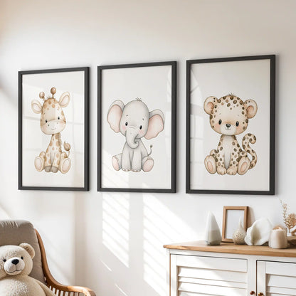 A set of three giraffe, elephant and leopard prints in black frames above a dresser in a kids' room.