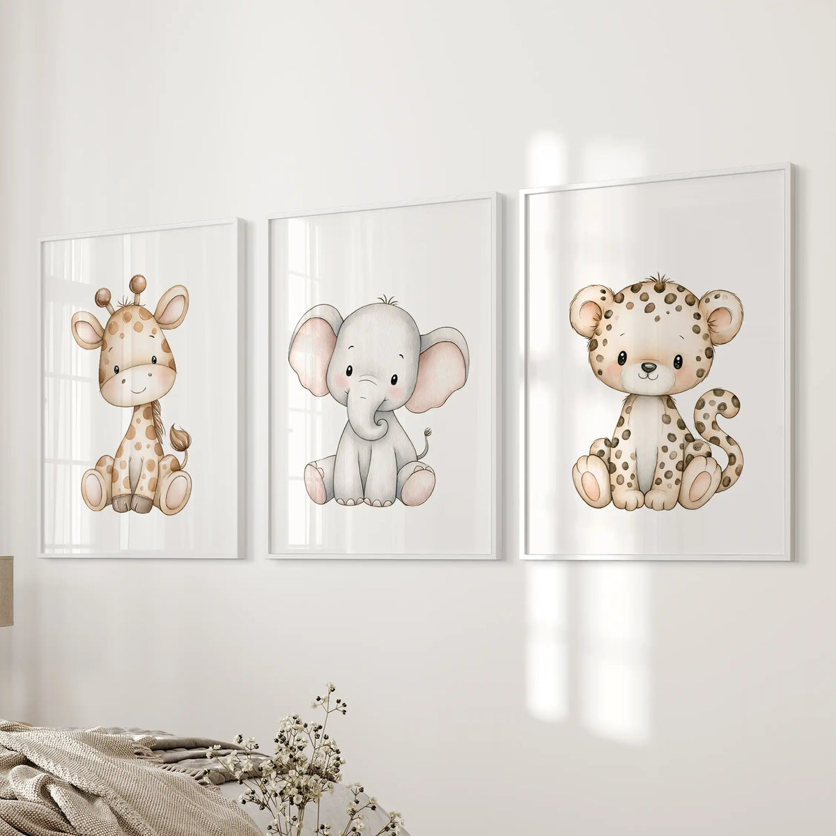 A gray elephant sits between a giraffe and leopard cub in three white-framed prints beside a bed.