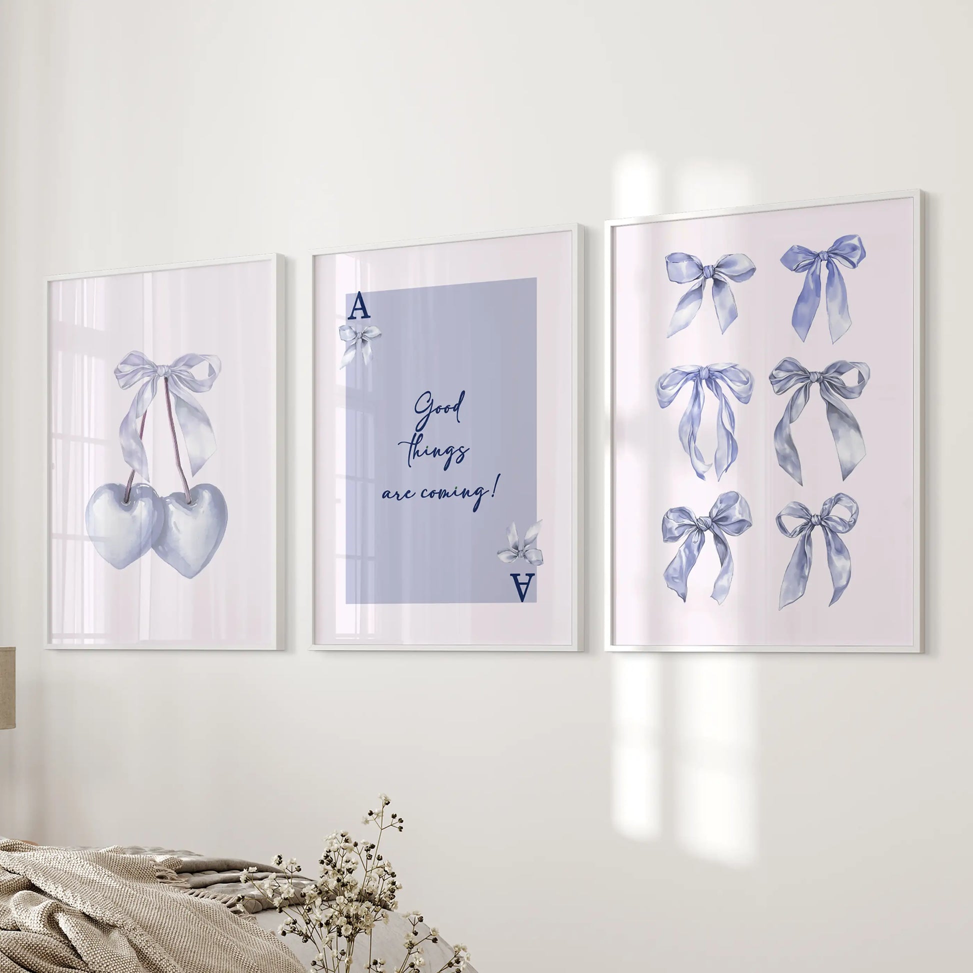 Set of three blue cherry illustrations in white frames hang beside the bed, sprinkling playful color throughout a cozy bedroom.