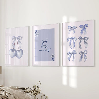 Set of three blue cherry illustrations in white frames hang beside the bed, sprinkling playful color throughout a cozy bedroom.