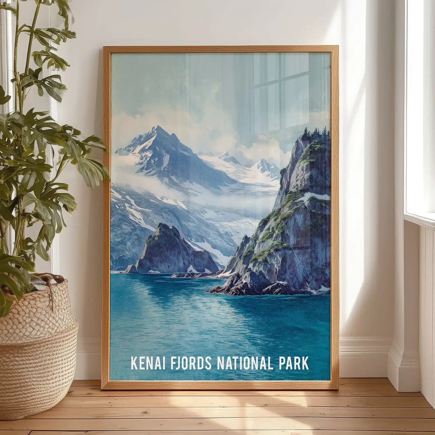 A vintage Kenai Fjords travel print leans casually on the bedroom floor, its light wood frame warming the scene near the dresser.