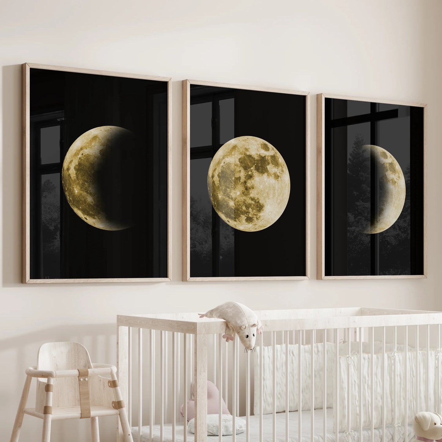 A baby room wall decor set of three wooden-framed moon prints hangs above the cot, the lunar cycle gently soothing the space.