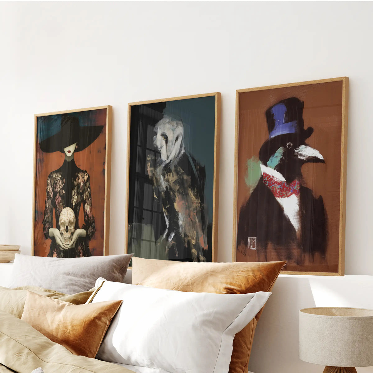 Gothic cottagecore three-piece wall art set in natural wood frames, arranged above the bed in a bedroom with owl, skull and raven motifs.
