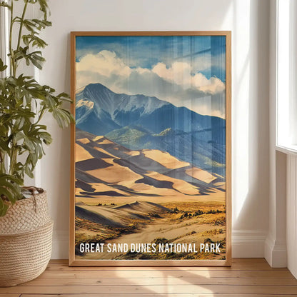 This oak-framed wall print of the Great Sand Dunes, propped against a bedroom wall, infuses the soft layers with a calm, sunlit desert mood.