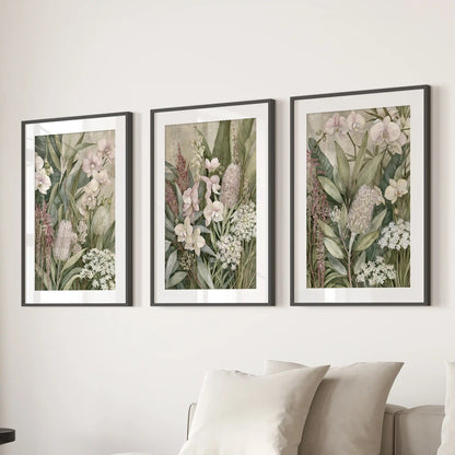Matted black frames hold three tropical botanical prints above a sofa.