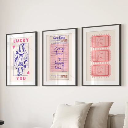 Pink ticket stub prints, an art set of 3, are matted in white within black frames and sized to line the living room wall above the couch.