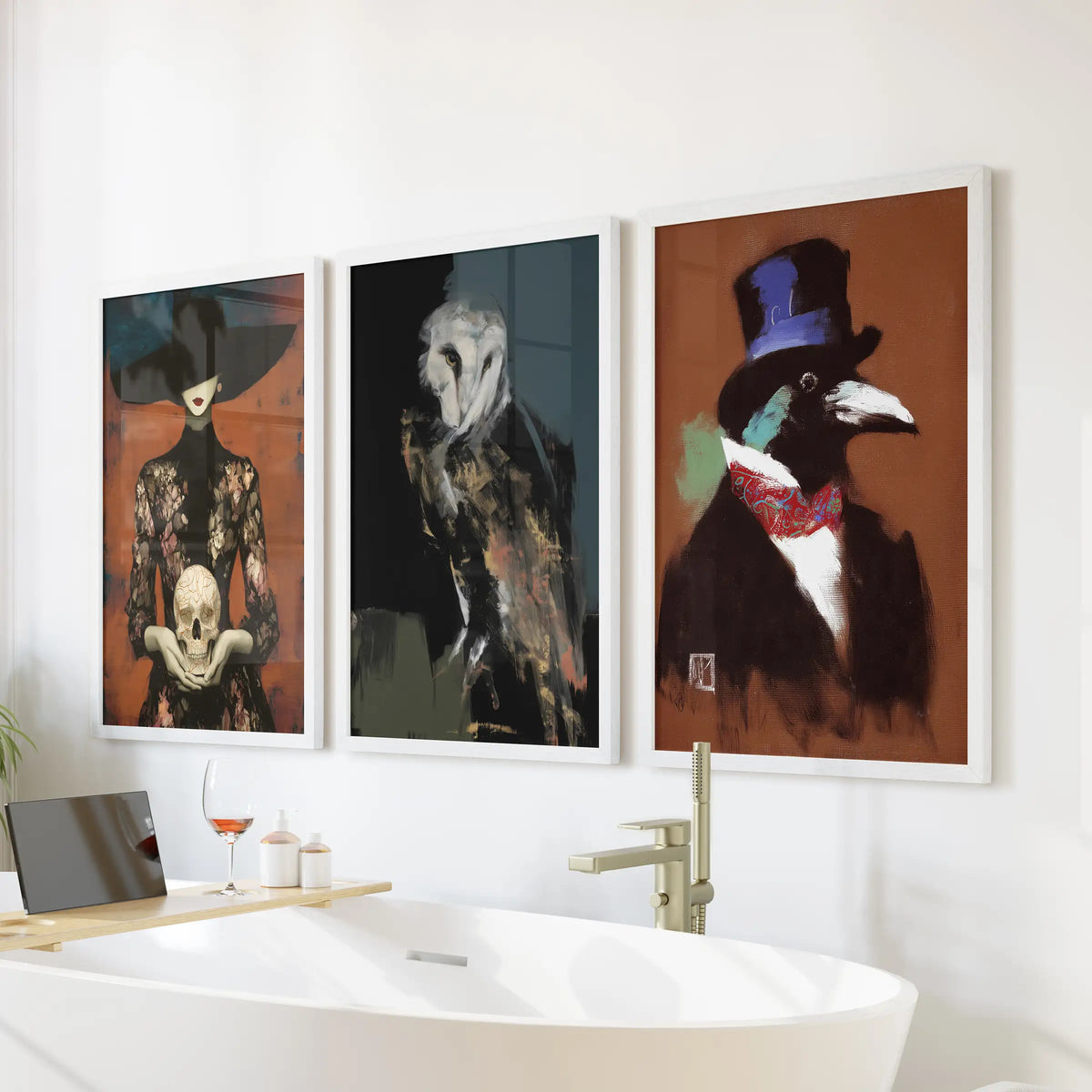 Set of three occult wall prints featuring an owl, skull, and raven in white frames, displayed above a bathroom tub.