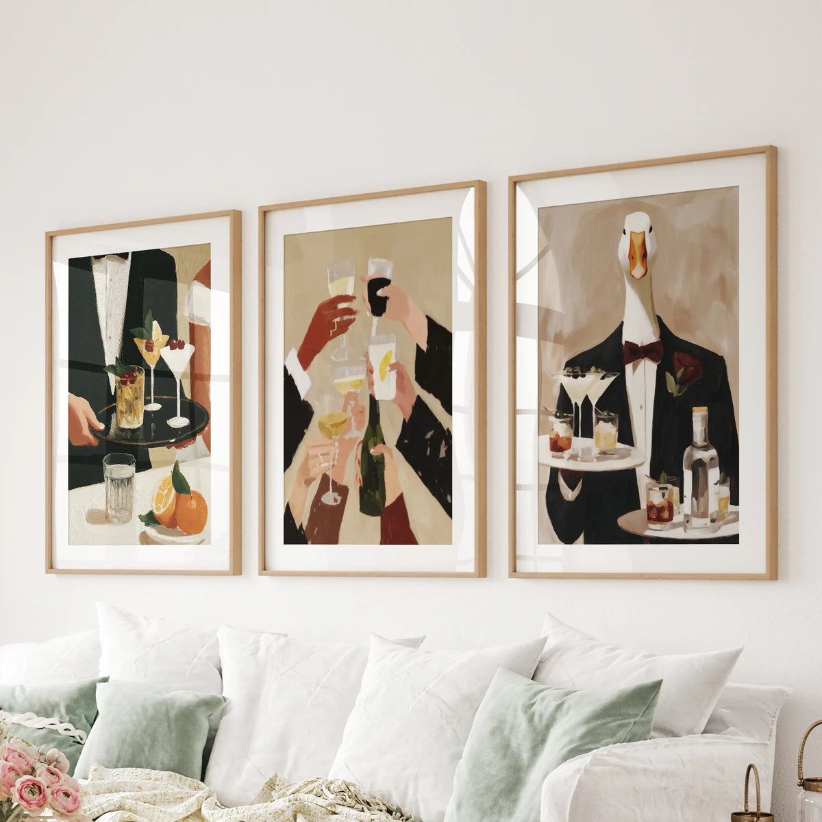 Happy hour wall art in a 3-piece poster set, hung in matted oak frames behind a lounge couch.