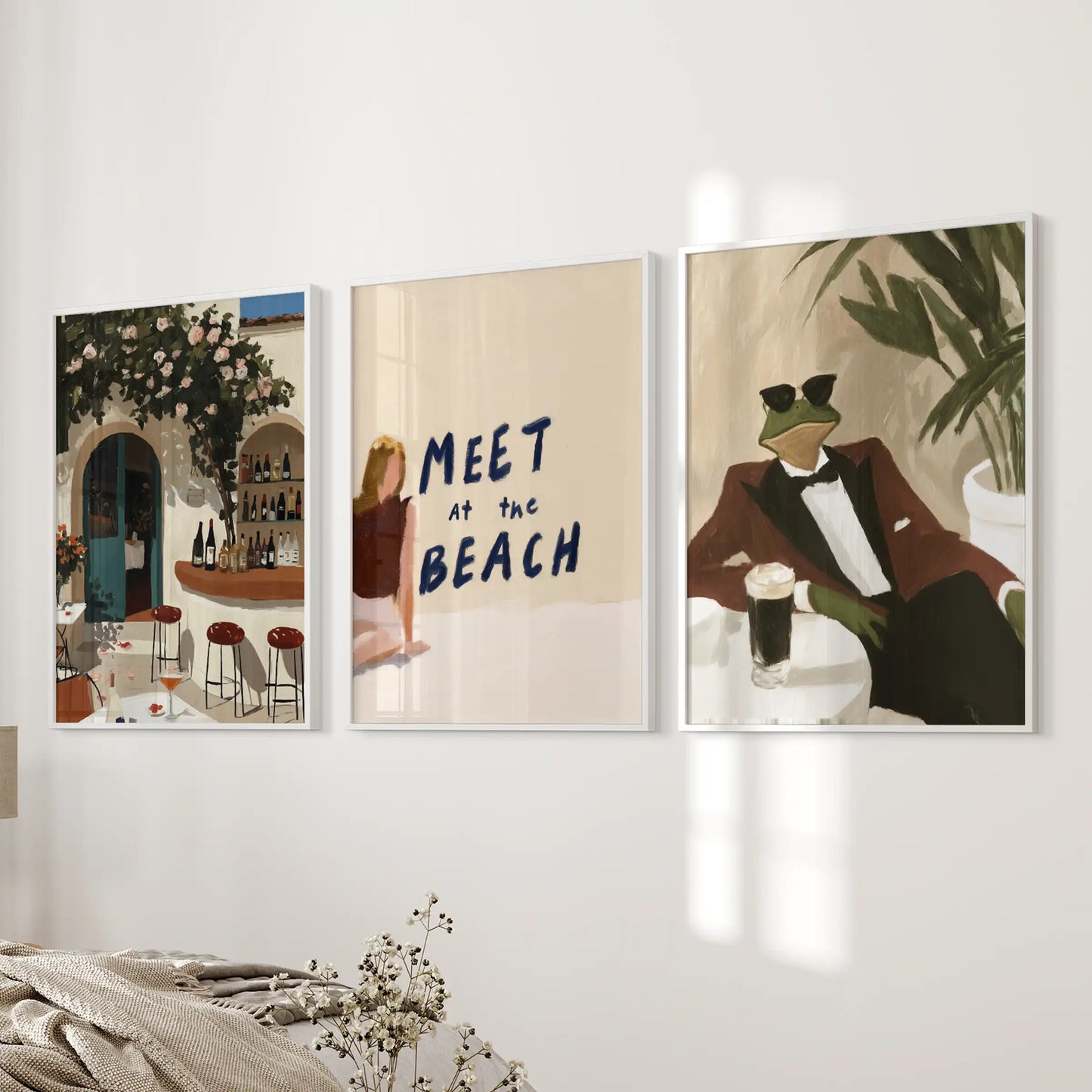 An Italian café triptych in white frames warms a bedroom wall with simple charm and a gentle, uncluttered character.