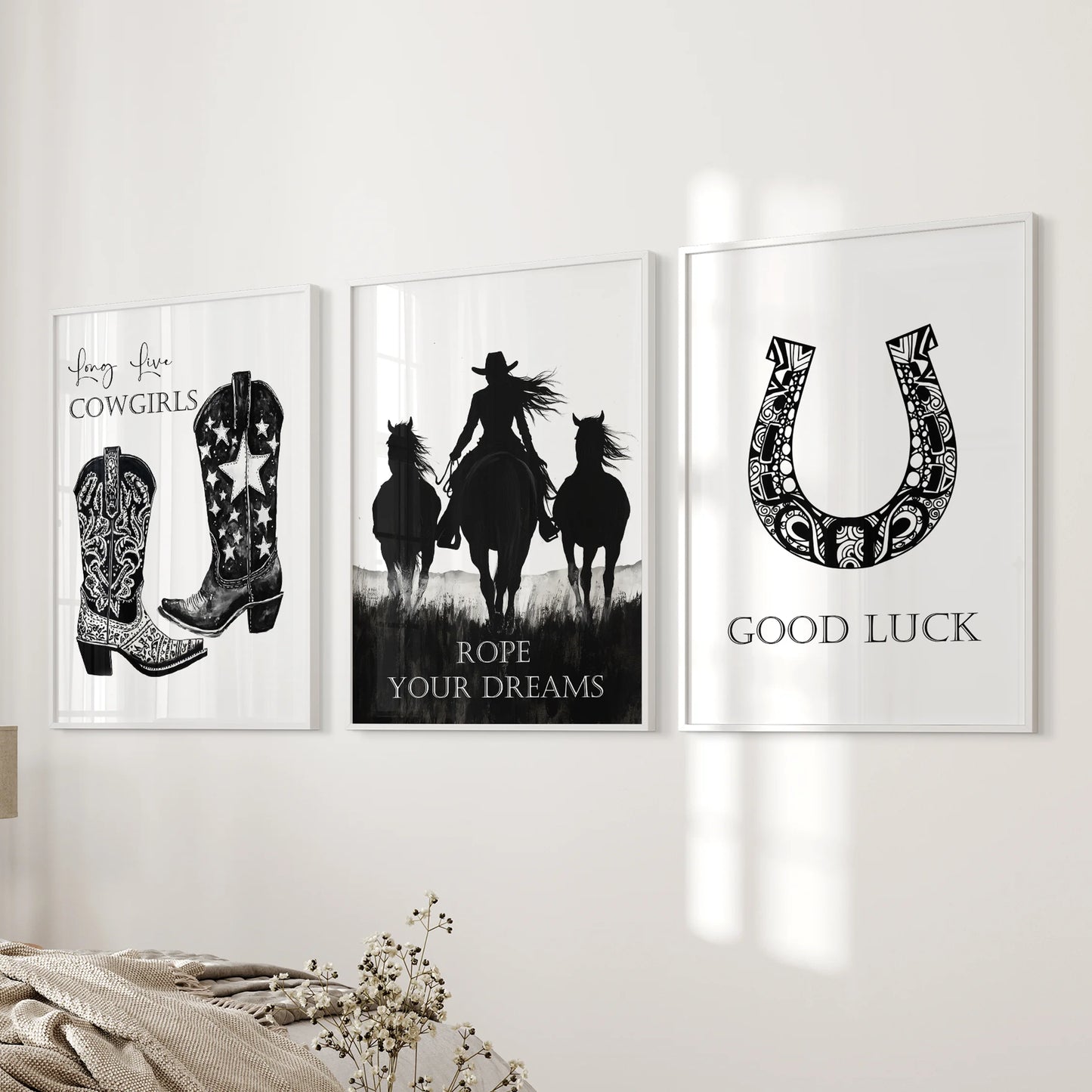 A white-framed set of three horseshoe prints hangs beside the bed, offering gentle Western imagery and a quiet sense of good luck.