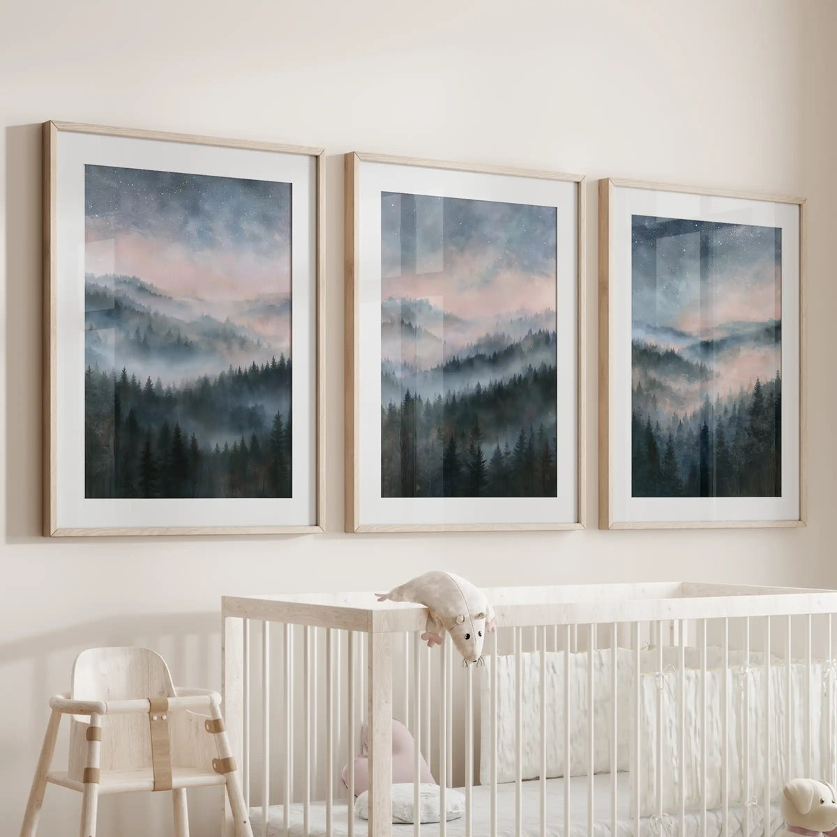 Moody misty hills wall posters come in a three-print bundle, matted in natural wood frames and centered over the nursery bassinet.